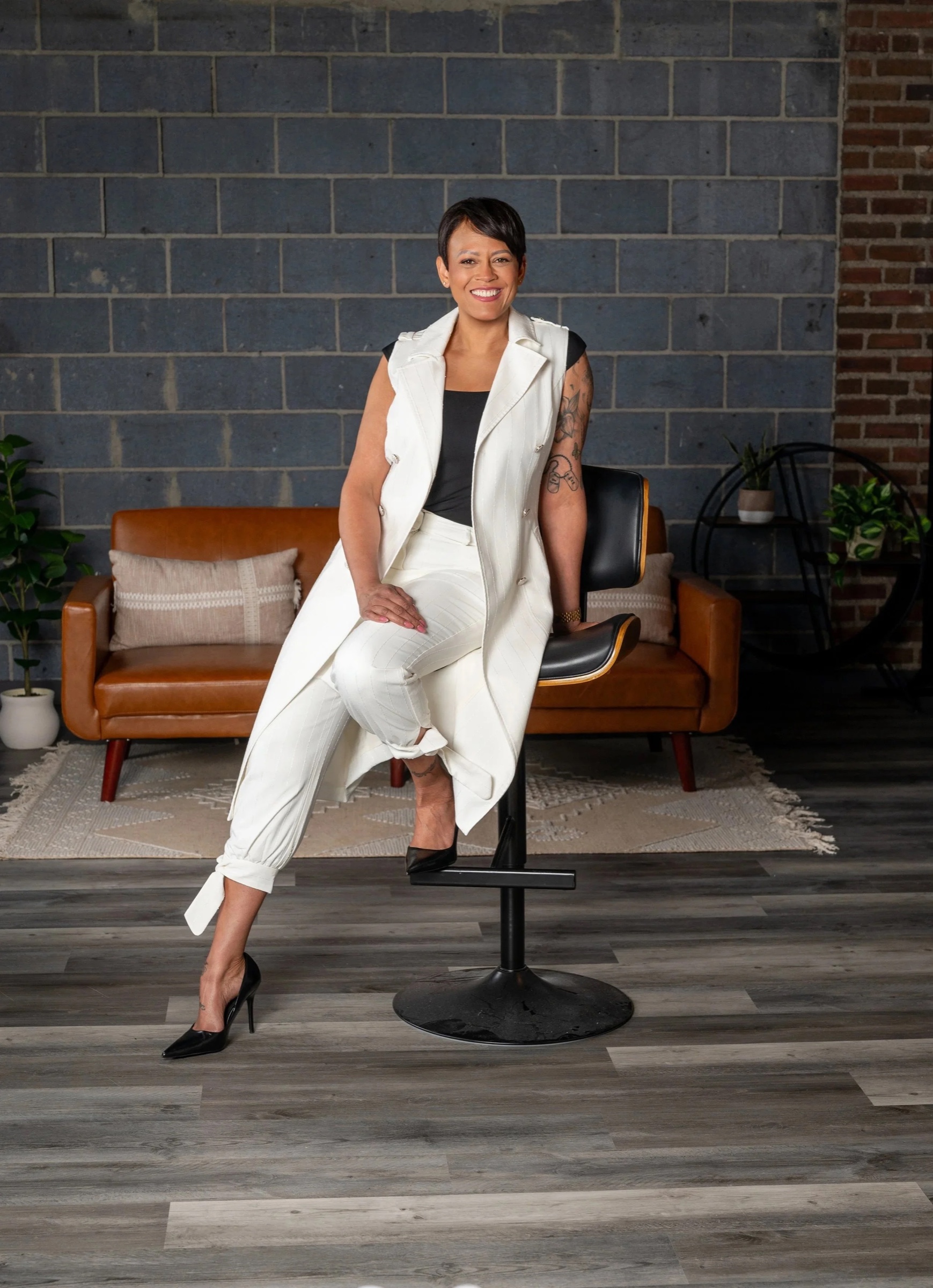 Lorrena Black in white, seated on a stool